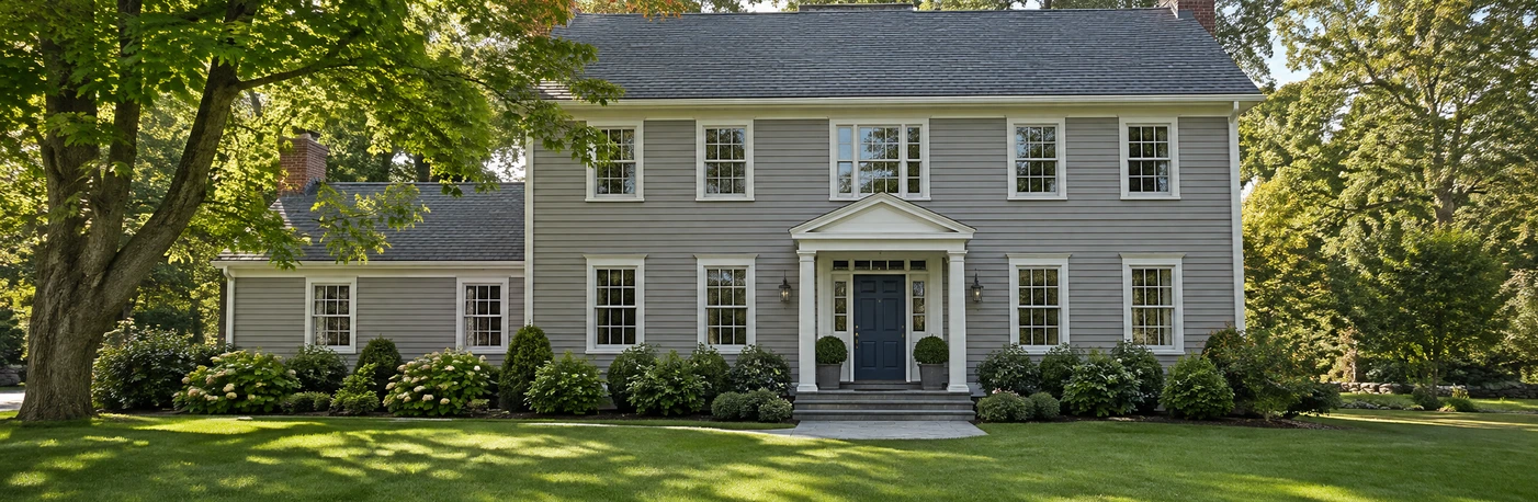 Illustration of a two-story house with gray siding, white trim and a green front lawn.